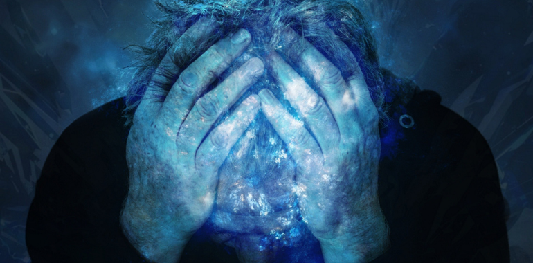 man holding head in hands - representing stress